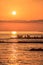 Scenic sunset landscape of Black sea coast with silhouettes of fishermen and sun reflection. Summer seaside vertical scenery