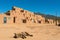 Scenic Taos Pueblo village in New Mexico, dog sunbathing in front