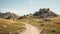 A scenic trail leading through a grassy landscape towards rocky hills under a clear blue sky