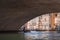 Scenic Venice Gondola Ride Under Arched Bridge with Reflections in Water