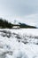 Scenic vertical view of a wooden cabin surrounded by lush trees on a winter day in Alberta, Canada