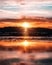 Scenic vertical worm\\\'s eye view of the sunrise across the sea behind the silhouette of a mountain