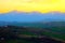 Scenic view from above at hills and mountains under the yellow sunset sky in Monte Vidon Corrado