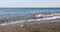 Scenic view of beach with waves and stone shore on sunny day