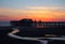 Scenic view of blackpool north pier in glowing red evening light just after sunset with illuminated pink and yellow sky and clouds