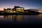 Scenic view of a calm reflective lake and Oslo opera house with illuminated lights during sunrise