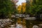 Scenic view of the calm rocky river along autumnal trees