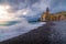 Scenic view of Camogli seaside with cloudy dramatic sky sea waves and buildings