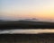 Scenic view of coast against sunset sky