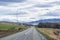 Scenic view of empty road amidst green landscape towards mountains against sky