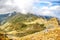 Scenic view of the Fagaras Mountains, with a lush valley surrounded by towering rocky peaks