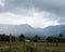 Scenic view of fenced green fields against farms in Aberdare Range on a cloudy day in Kenya