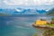 Scenic view of fjord, snow mountains and house,