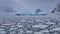Scenic view of glaciers floating in the ocean on a snowy mountain background in Svalbard