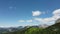 Scenic view of green pine trees on a slope of rocky mountains on a sunny day