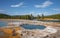 Scenic view of hotspring by Firehole River in Midway Geyser at Yellowstone park