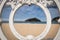 Scenic view on isand santa clara from san sebastian concha beach through ornamental white iron fence frame, basque country, spain