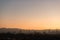 Scenic view of Kuala Lumpur city skyline against dawn sky with low clouds.