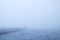 Scenic view of a lake with a pier covered in fog