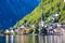 Scenic view of a lake with shoreline buildings and green mountain forests, Hallstatt, Austria