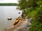 Scenic view of the lake and a yellow kayak pulled out on the stones of a small shore of a forested island
