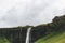 scenic view of landscape with Seljalandsfoss waterfall in highlands under cloudy sky