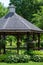 Scenic view of a landscaped wooden gazebo in a city park setting