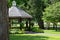 Scenic view of a landscaped wooden gazebo in a city park setting