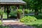 Scenic view of a landscaped wooden gazebo in a city park setting