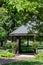 Scenic view of a landscaped wooden gazebo in a city park setting