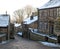 A scenic view of the main street in the village of heptonstall in west yorkshire with snow covering the old stone houses and