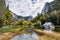 Scenic view of Mirror lake, along Tenaya Creek; surrounding mountain ridges reflected in the shallow, calm waters of the lake;