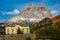 Scenic view of a mountain towering over colorful forest and calm lakefront hotel