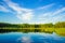 Scenic view of nature with lake, blue sky and forest reflected in water - Summer quiet landscape of Scandinavia