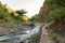 Scenic view of Ngare Sero river against volcanic rock formations near Lake Natron in Tanzania