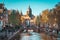 Scenic view of the Oude Church and the Oudekerksbrug Bridge with a lot of tourists on a sunny day