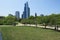 Scenic view of people riding bicycles in a green park against modern skyscrapers in Chicago