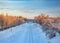 Scenic view of railway along snowy trees at sunrise