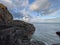 Scenic view of a rocky coast under a cloudy sky background