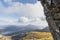 A scenic view of a Scottish mountain valley with stalactites on a rock in the foreground, grassy slope with autumn color and a