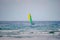 Scenic view at small catamaran with yellow green blue sail sailing in sea. Team of unrecognizable people enjoy together tropical