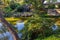 Scenic view of a small waterfall cascading down onto a river below in a Japanese garden