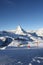 Scenic view on snowy Matterhorn peak in sunny day with blue sky and some clouds in background