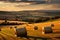 a scenic view of some farm with bales and sunset