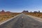 Scenic view of ta road leading to the Monument Valley with sandstone buttes on the background