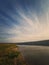 Scenic view to the riverbank of Nistru river, Moldova. Vertical background, calm water flowing. Natural landscape, silent empty