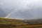 Scenic view to Scottish highlands with rainbow through the clouds