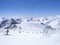 Scenic view from top of Wildspitz on winter landscape with snow covered mountain slopes and pistes and skiers on chair