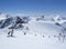 Scenic view from top of Wildspitz on winter landscape with snow covered mountain slopes and pistes and skiers on chair