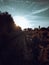 Scenic view of an unpaved road  on the side of an agricultural field against a bright sunny sky